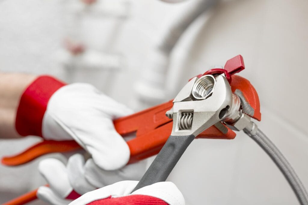Plumber tightening pipe fitting for residential plumbing repair in Royal Palm Beach, Florida