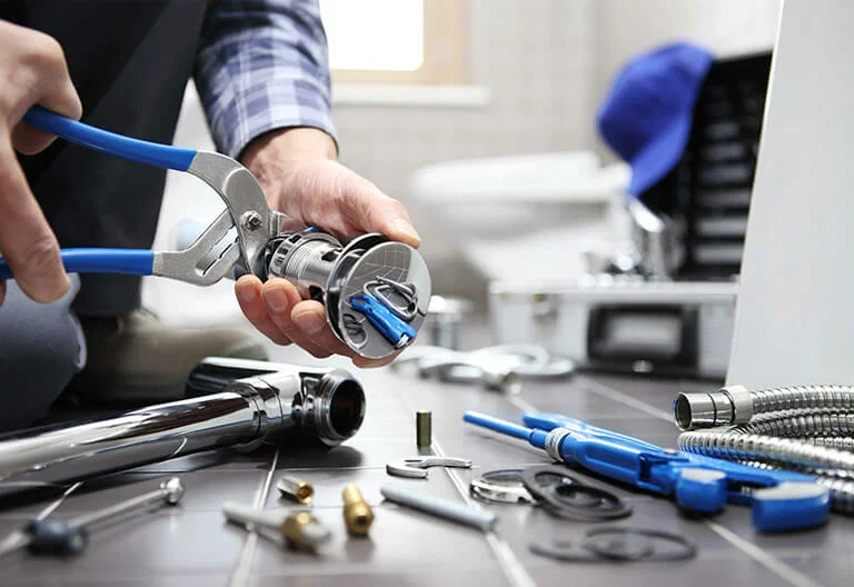 Technician repairing a plumbing fixture with professional tools in Royal Palm Beach