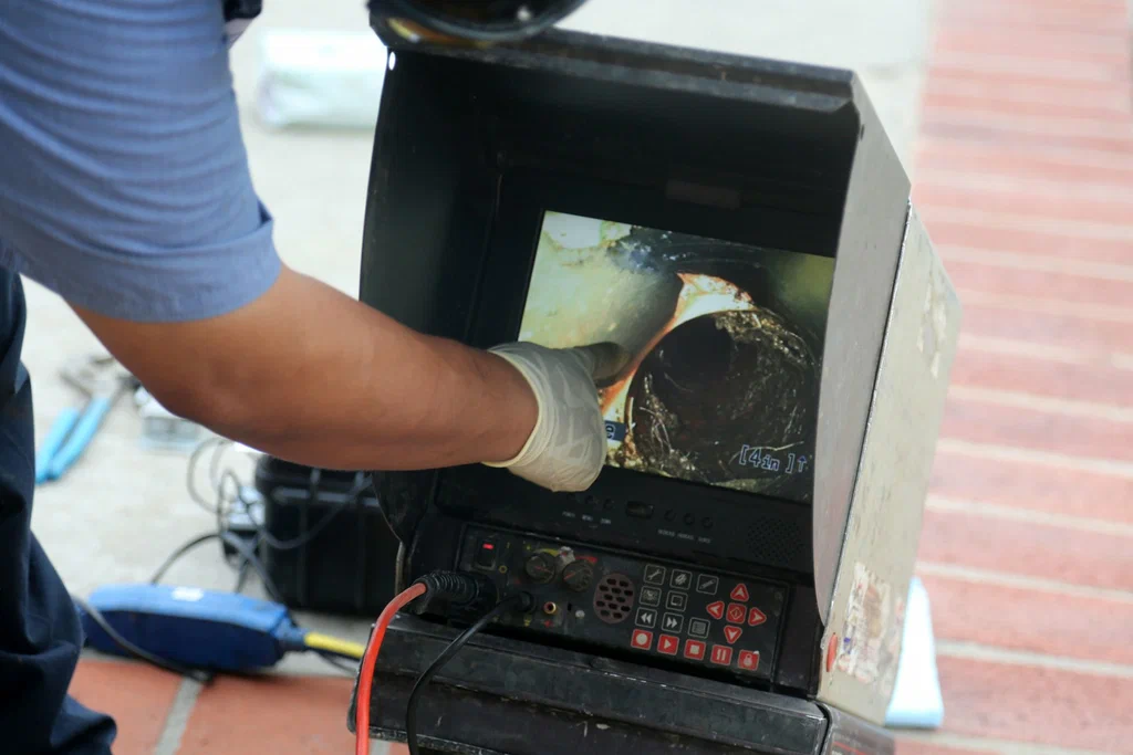 Technician viewing a drain inspection camera in Royal Palm Beach