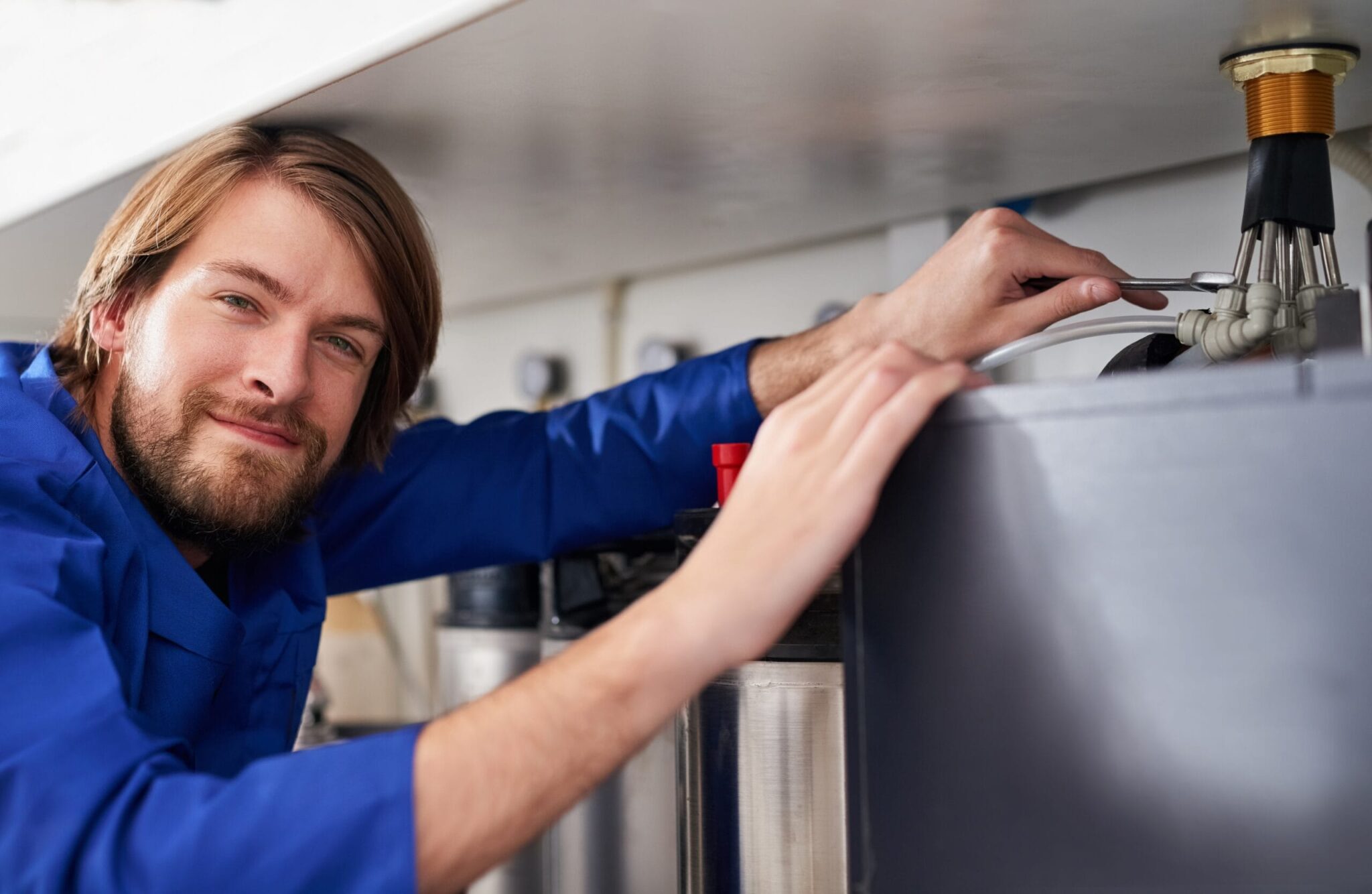 Technician servicing a residential water heater tank in Royal Palm Beach