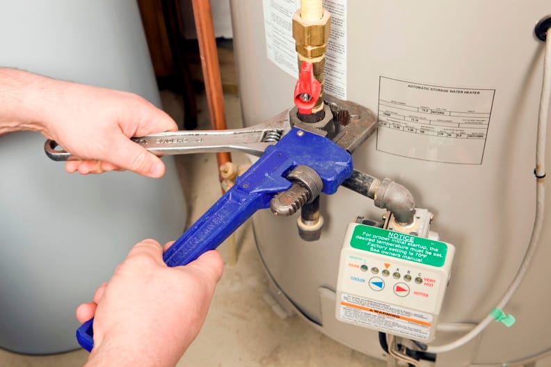 Plumber repairing a water heater valve in Royal Palm Beach